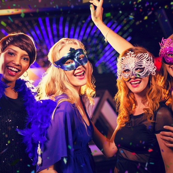 Group of smiling friends dancing on dance floor against flying colours