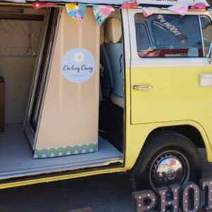 starting a campervan photo booth business image featuring yellow wesfalia camper with Magic Mirror photobooth inside